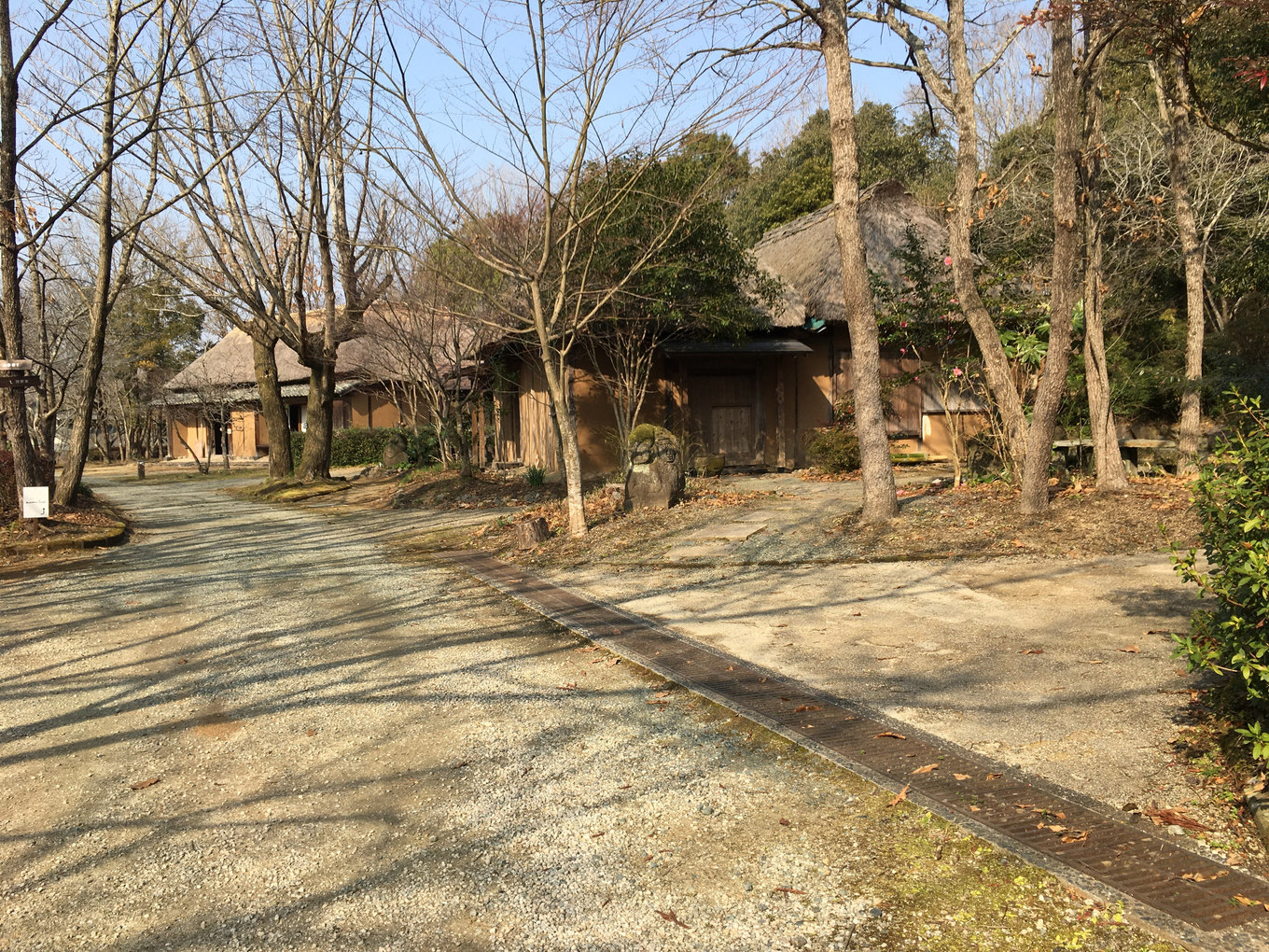 木立の中に古民家が点在する肥後民家村の散策路