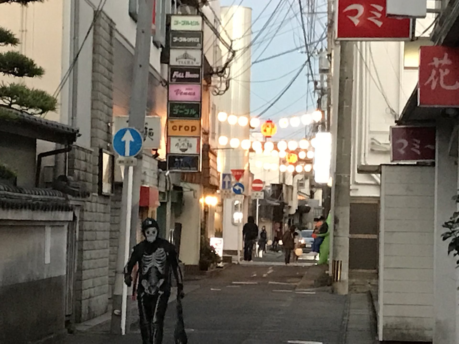 伊万里横丁でガイコツの仮装をした人が歩く夕方の路地