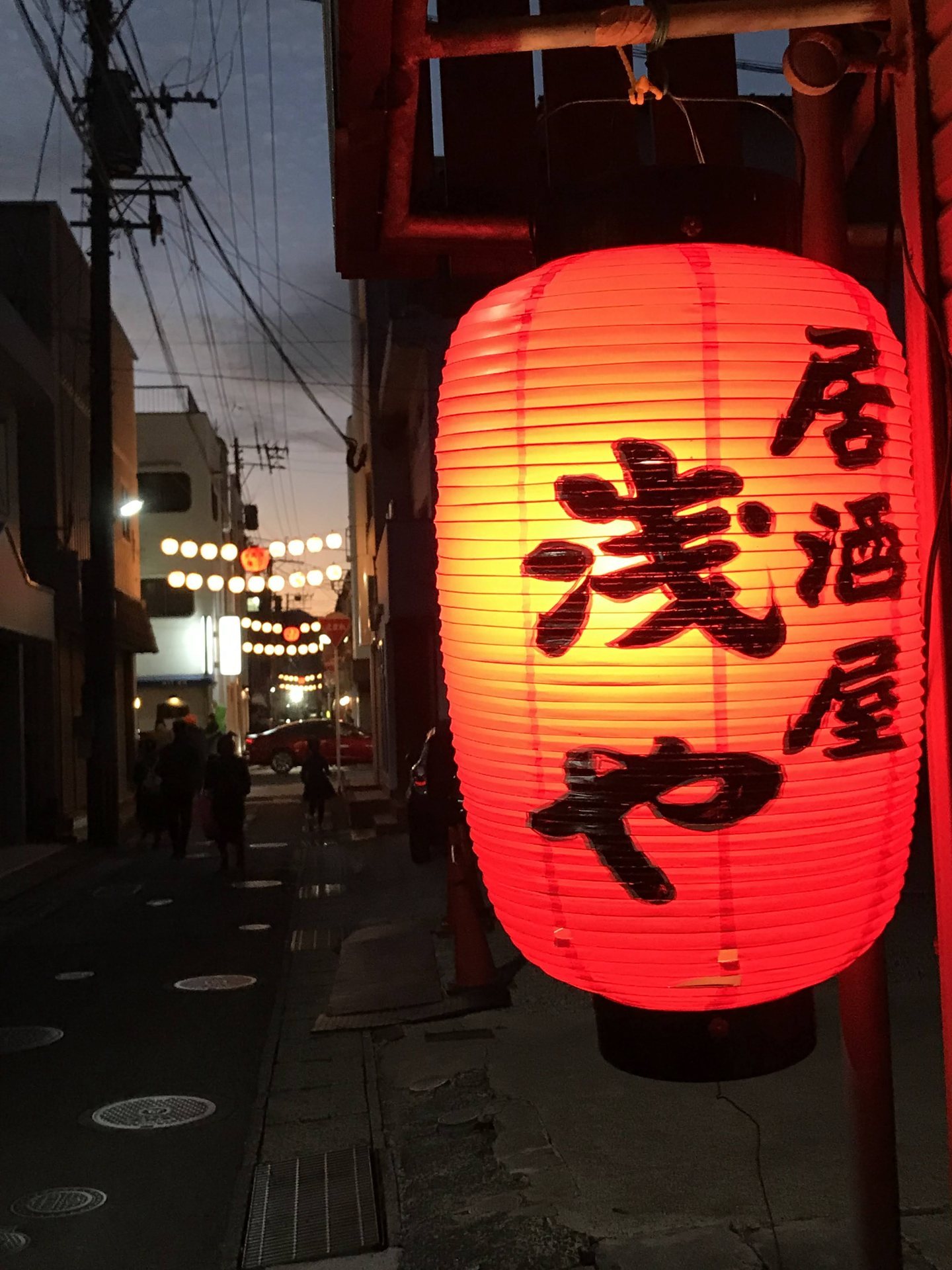 伊万里横丁の赤い居酒屋の提灯と奥まで続く小路の灯り