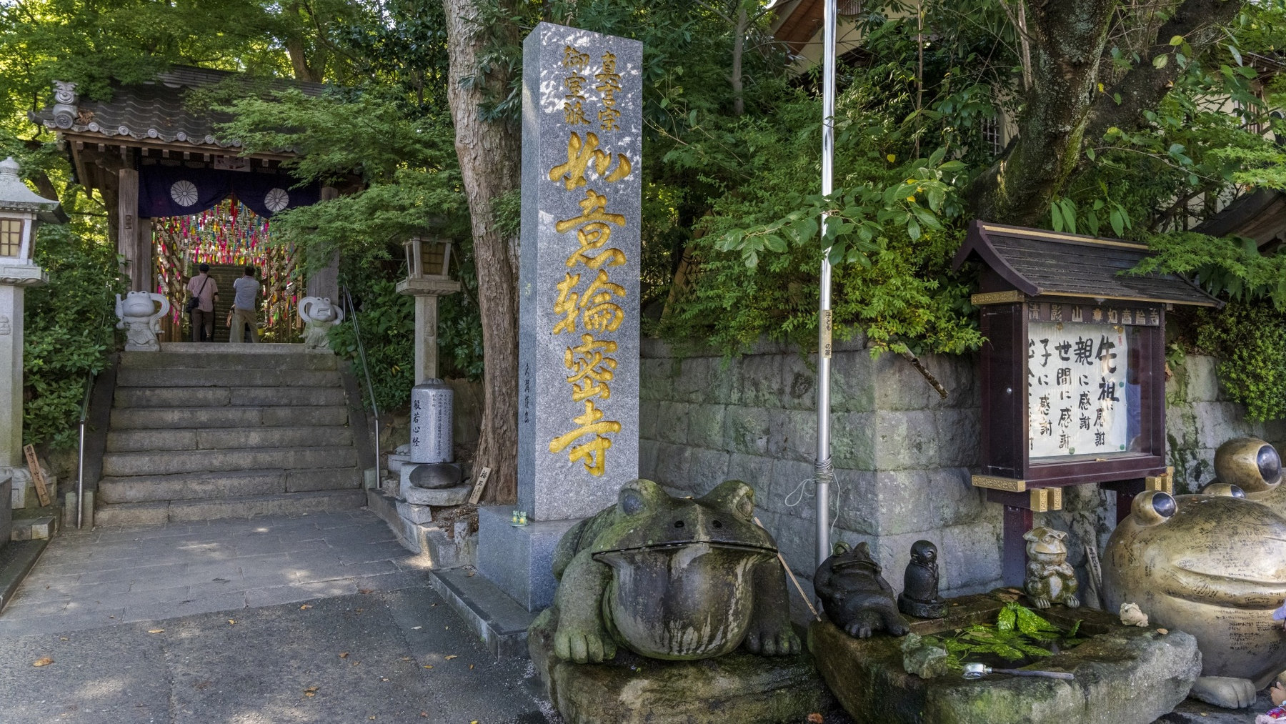 如意輪寺の寺号標とカエルの石像がある参道入口