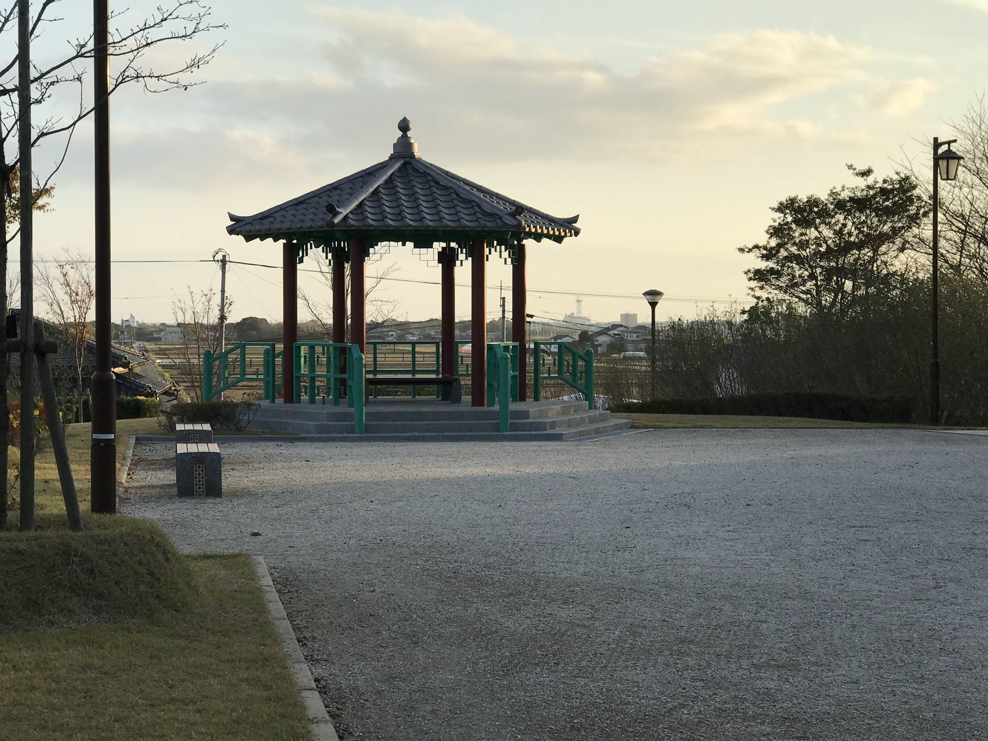 夕方の光を背景にした王仁博士顕彰公園の休憩舎
