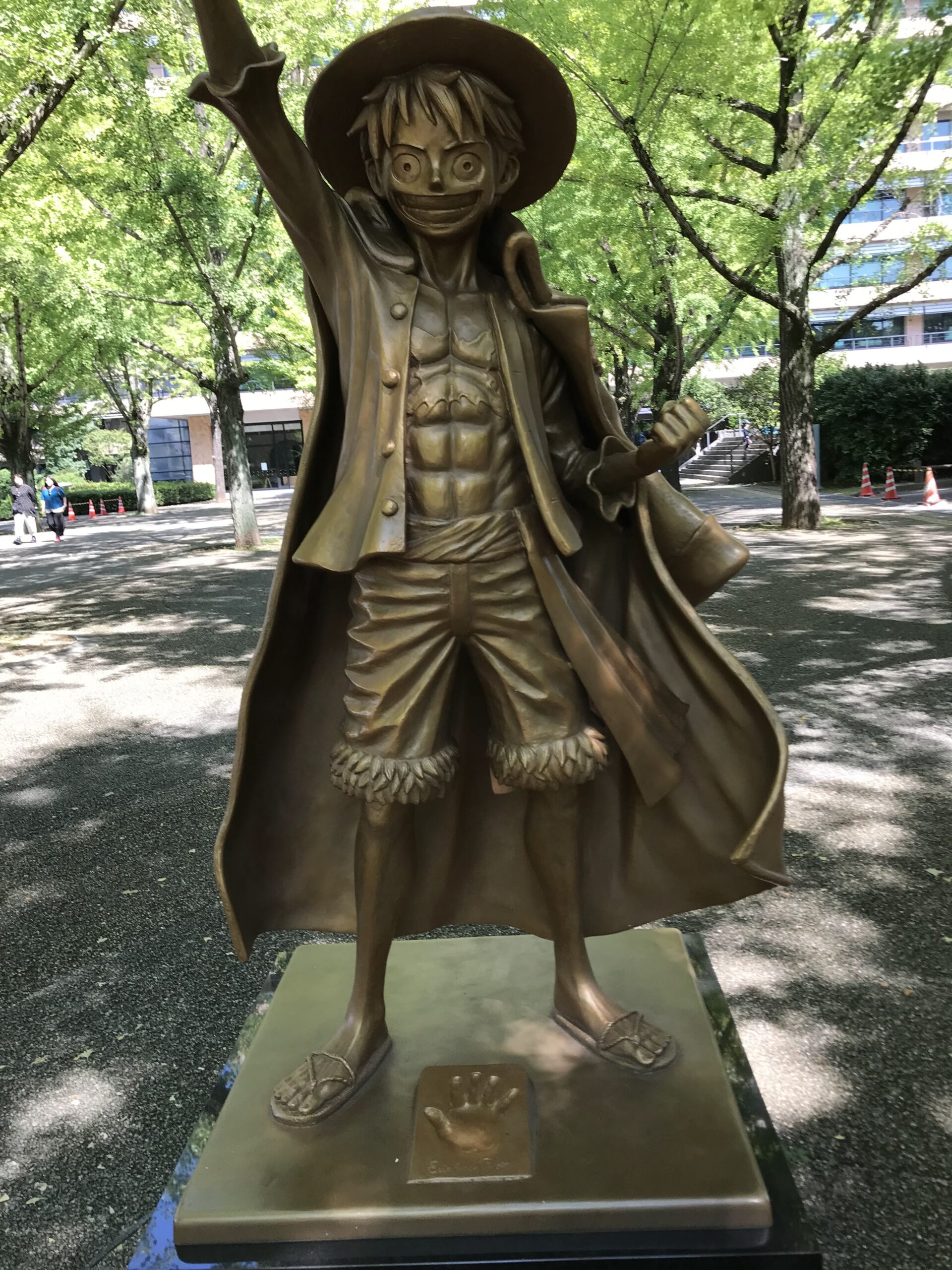 麦わら帽子をかぶり片腕を上げた熊本県庁のルフィ像の全身（2022年）