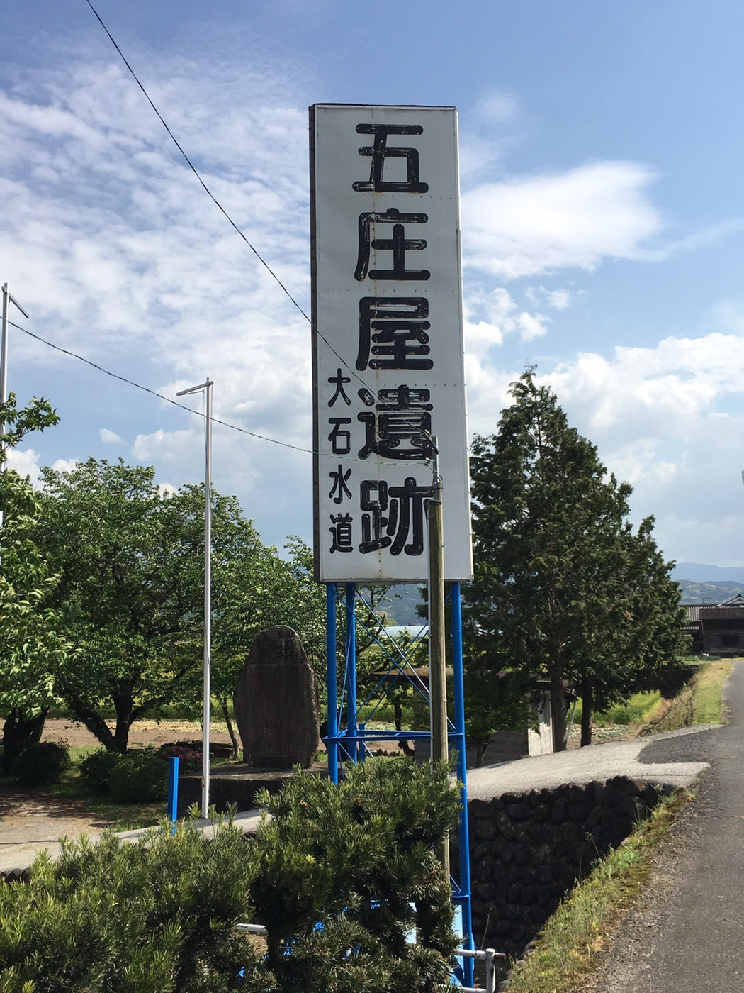 道路沿いに立つ五庄屋遺跡・大石堰の案内標識