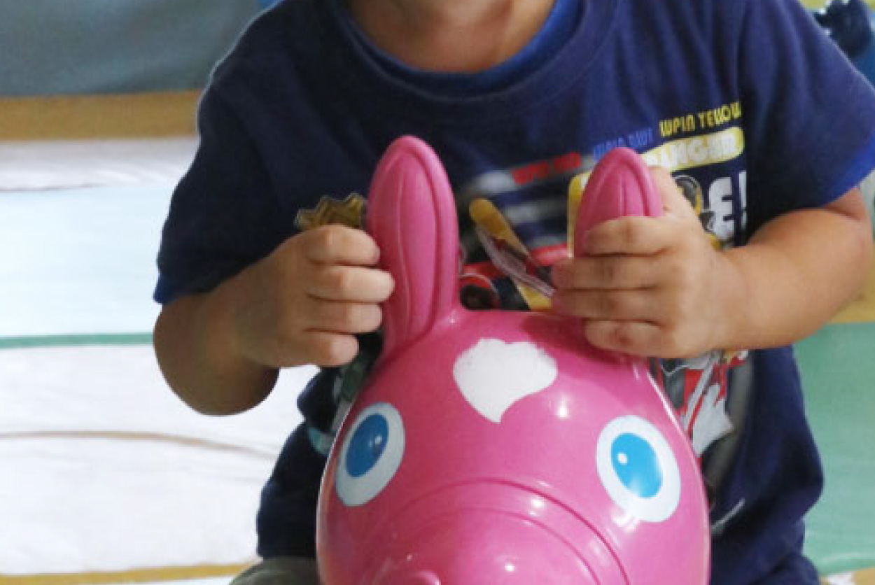 ピンク色のロディに手を添える子どもの写真