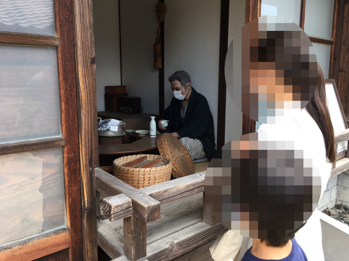 復元炭坑住宅で昔の暮らしを再現した人形を見つめる子どもたち