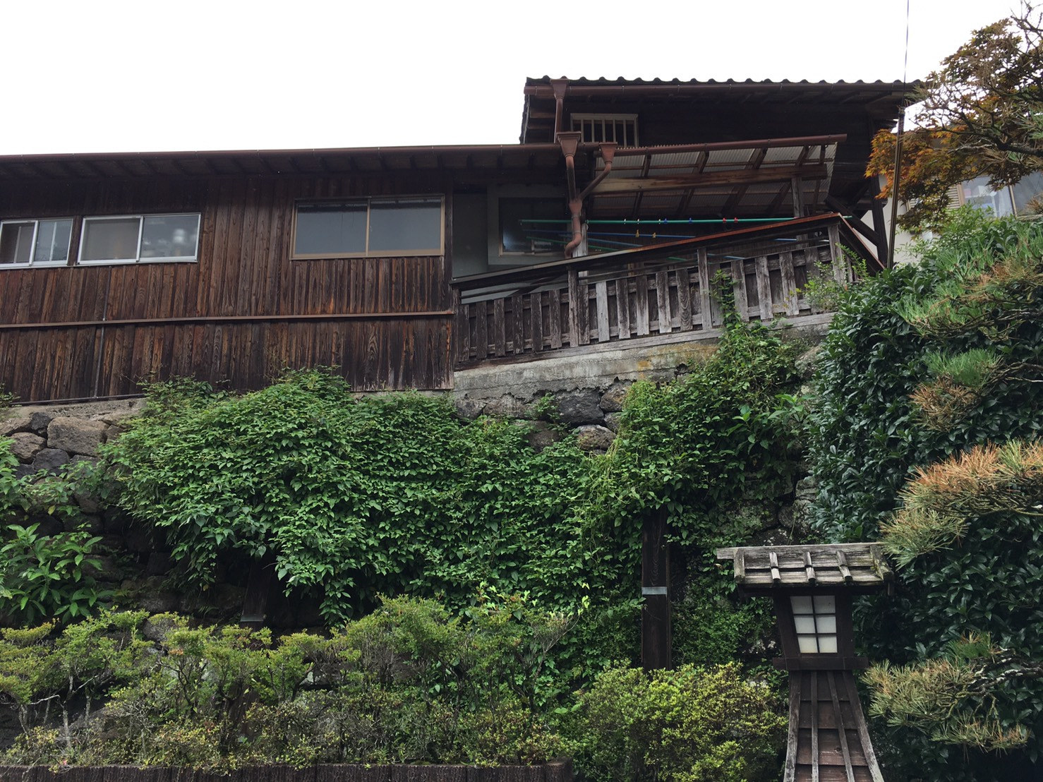 竹田城下町の石垣の高い位置に建つ木造住宅と緑