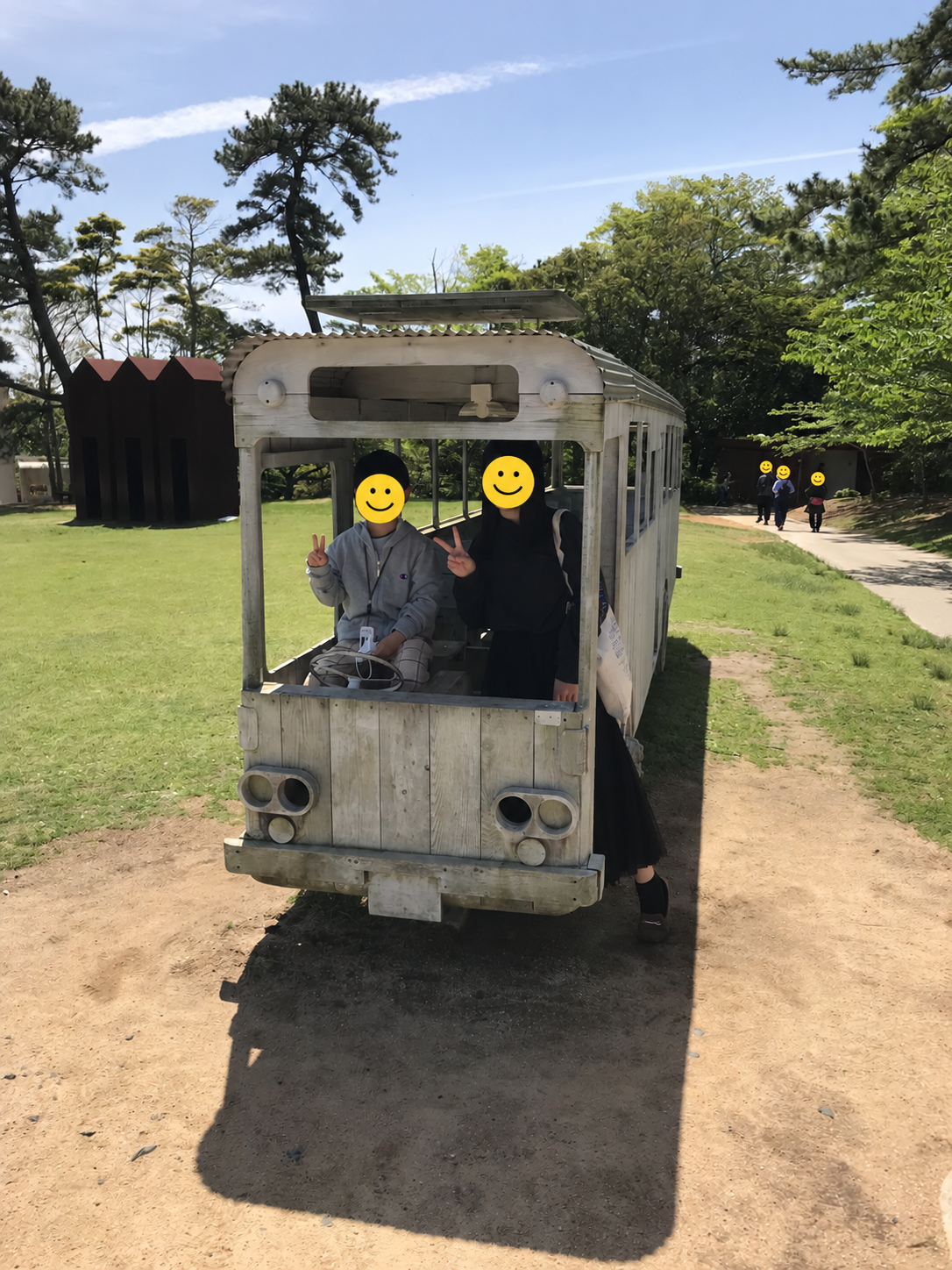 ときわ公園の白い木のバス型作品で記念写真を撮る成長した子どもたち