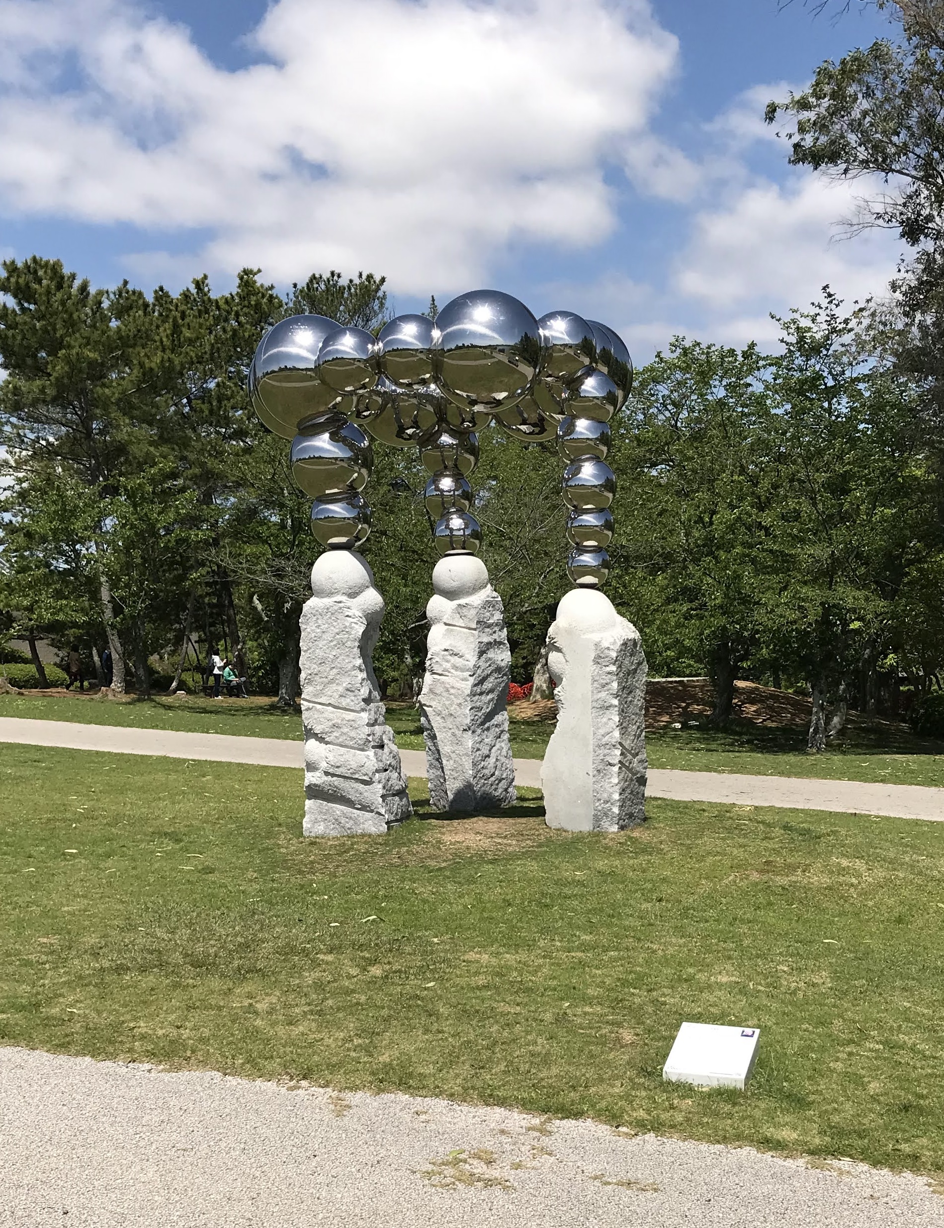 白い石の支柱の上に鏡のように輝く金属球が連なるときわ公園の彫刻