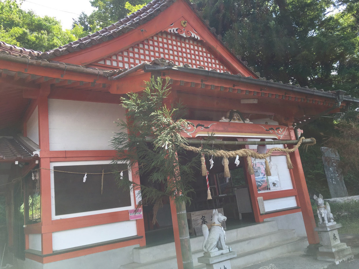 木々に囲まれた浮羽稲荷神社の赤い屋根の社殿