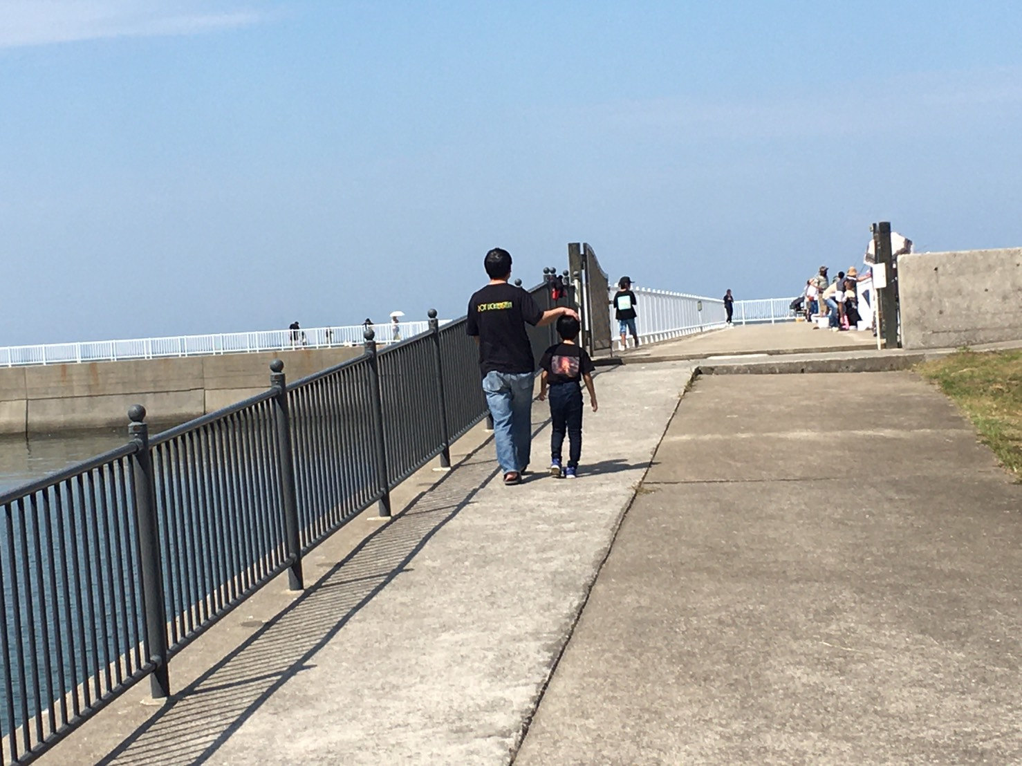 宇土マリーナで海沿いの通路を歩く親子の後ろ姿（2021年）